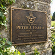 Right angle view of personalized bronze commemorative plaque showing its raised inscription and traditional cast metal finish