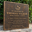 Right angle view of personalised bronze commemorative plaque showing its raised inscription and traditional cast metal finish